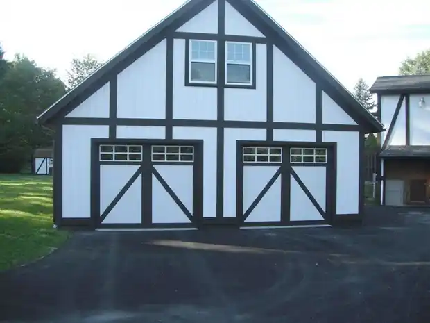 Black-trimmed white tudor-style garage with two X-brace doors