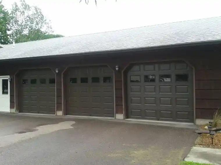 Three dark raised-panel doors under a long low roof