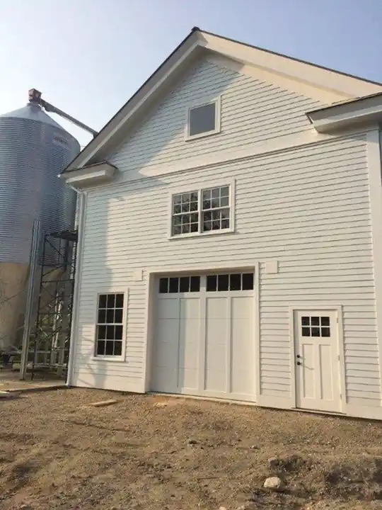 Cream carriage doors on a converted barn beside a grain silo