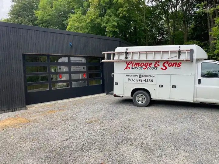 The Limoge & Sons service van, phone number on the side, parked by a black garage with a full-view glass door